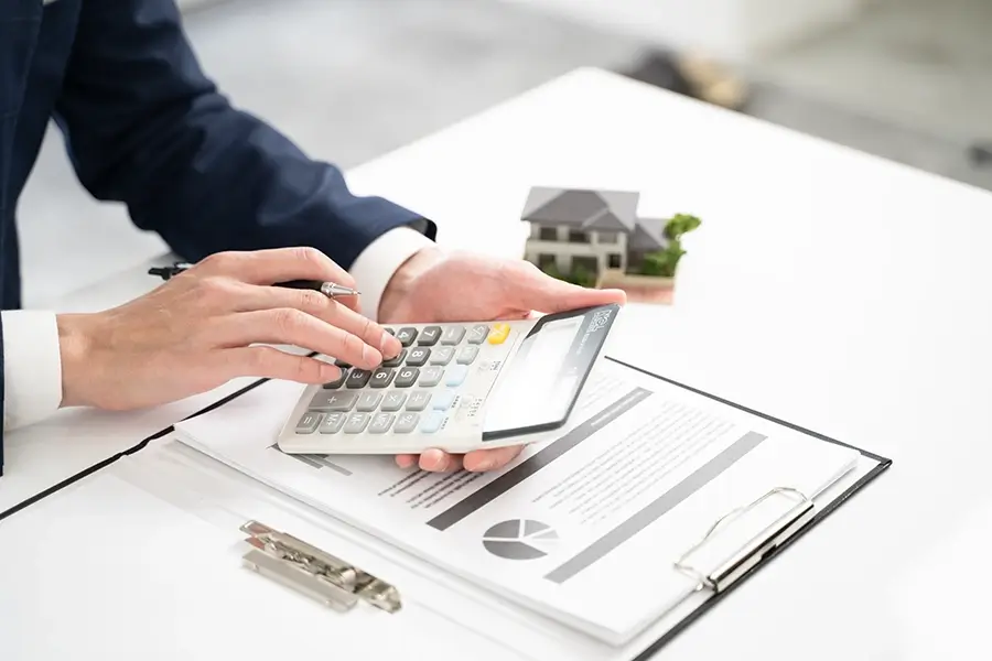 ビジネスマンが電卓で見積もりを計算している 写真